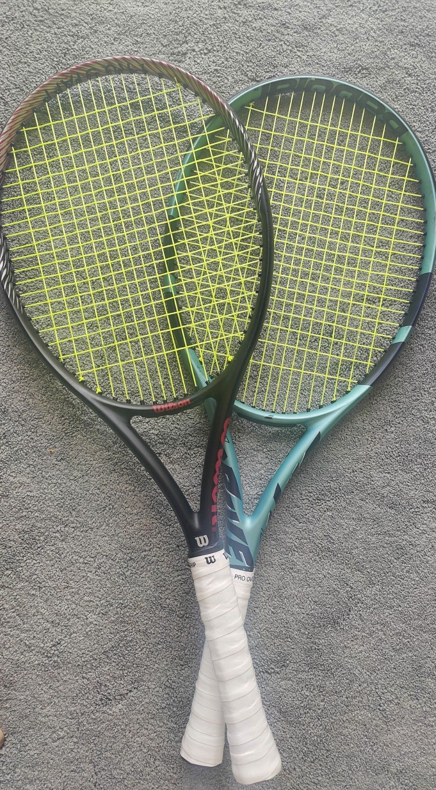 Two tennis rackets with fresh yellow strings and replacement grips